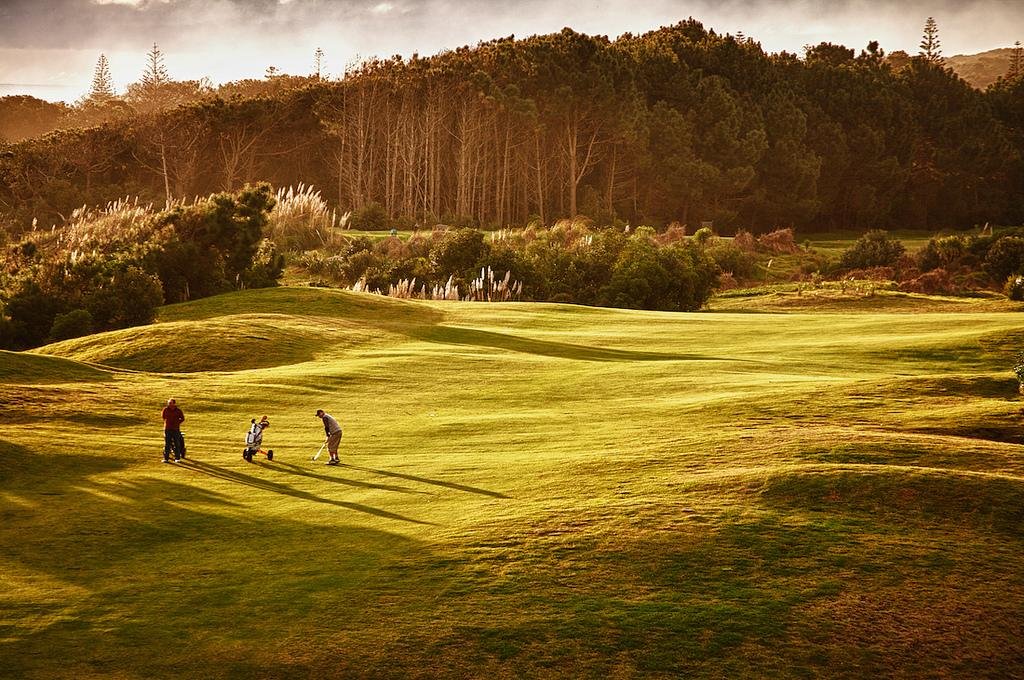 Golfers on an undulating fairway at Muriwai Golf Club